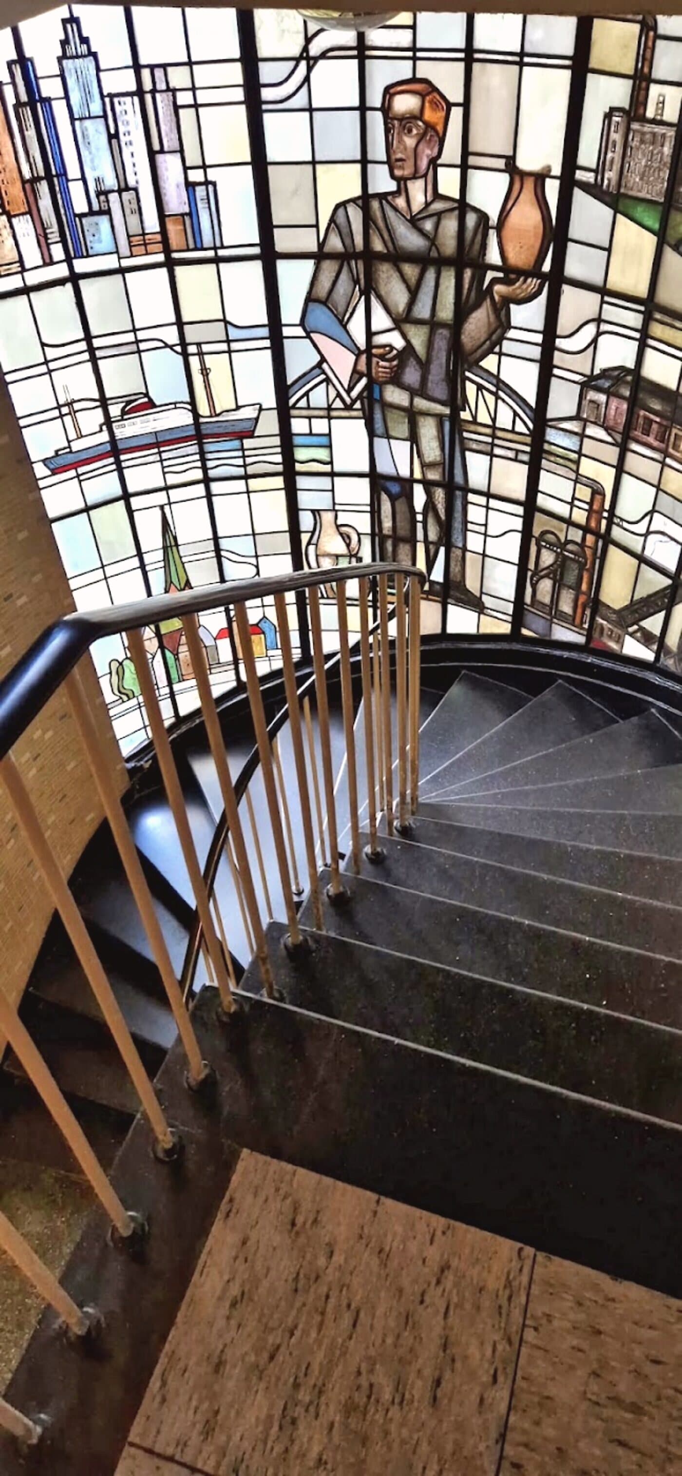 Geschwungene Wendeltreppe mit kunstvollem Buntglasfenster